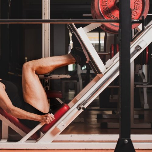 mujer levantando pesa con máquina de gimnasio